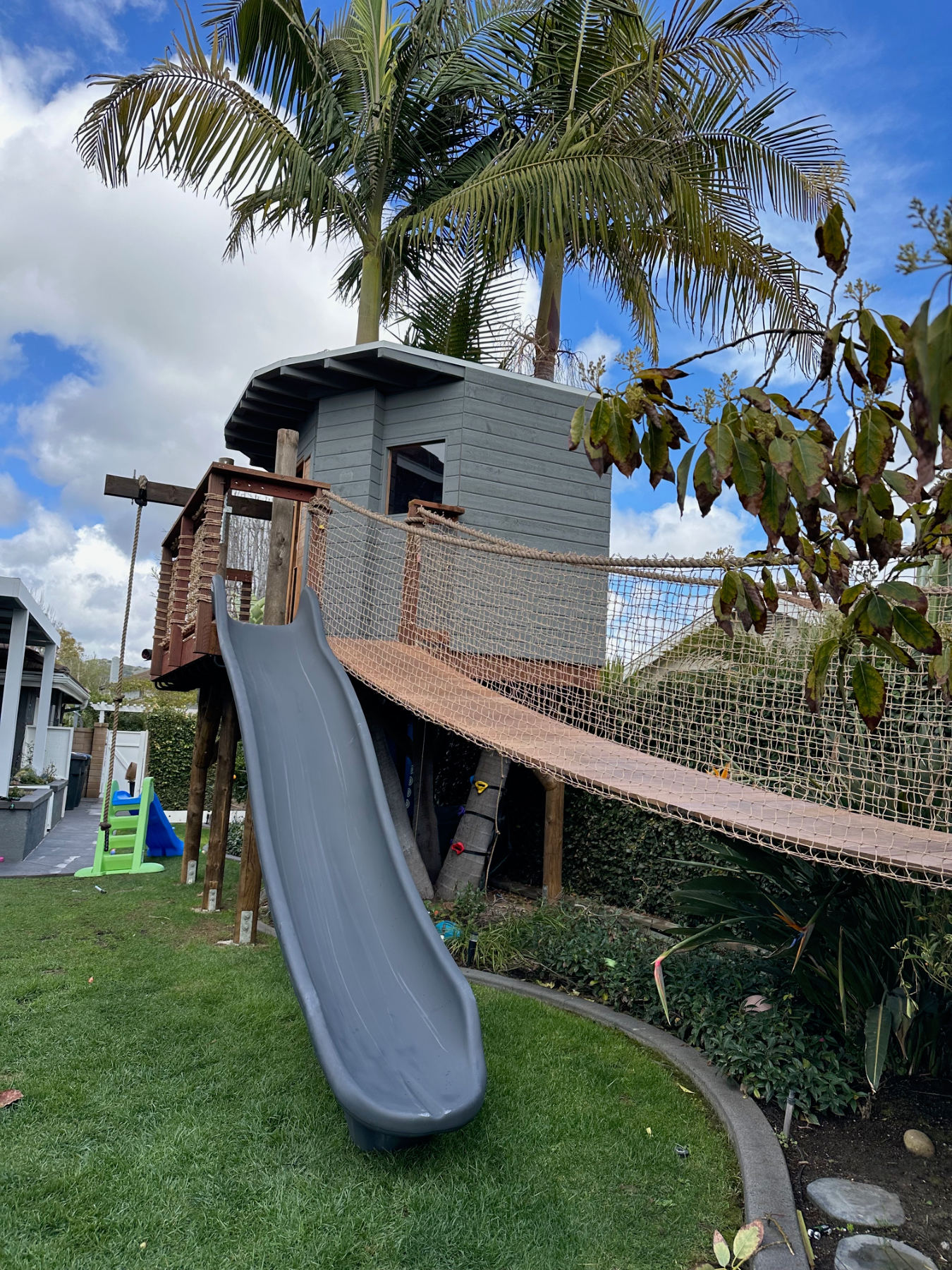 Completed custom tree house with suspension bridge and slide