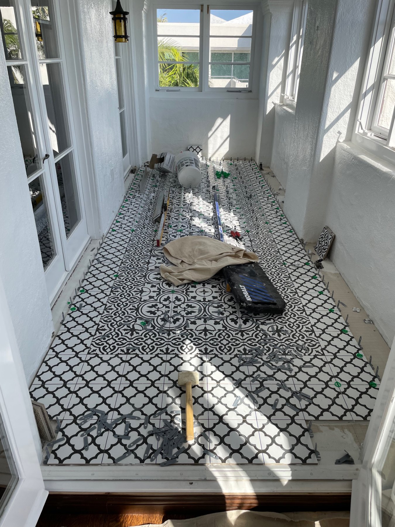Custom tile floor installation progressing across sunroom